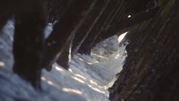 Fale Rozbijające Się Pod Molo Stare Drewniane Pręciki Promieniami Słońca — Wideo stockowe