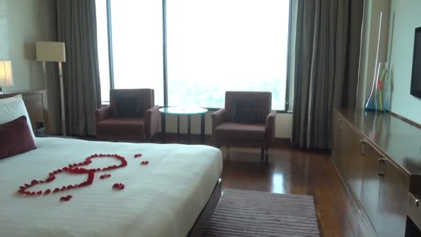 Bir Tatil Odasındaki Yatağın Ucuna Kırmızı Çiçek Yapraklarından Yapılmış Birbirine — Stok video