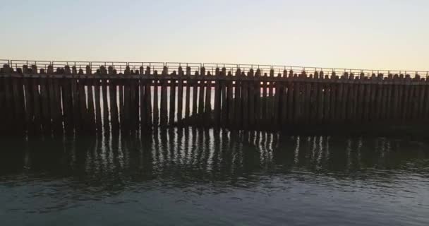 Luchtfoto Pier Het Strand Vuurtoren Bij Zonsondergang Bij Het Dorp — Stockvideo