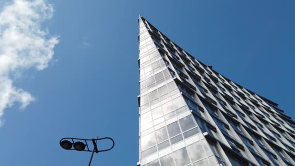 파란색 하늘을 배경으로 동시대 건물의 모서리를 각도로 화면을 확대하여 구름을 — 비디오