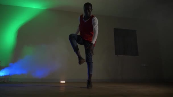 Afrikalı Gençlerin Kırmızı Tişört Giyip Renkli Disko Işıklarında Bacaklarıyla Zıplama — Stok video