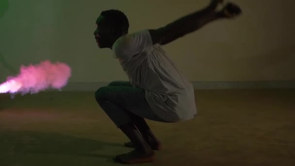 Afrikalı Gençlerin Renkli Dumanda Çömelmiş Bir Pozisyonda Ters Takla Atarken — Stok video