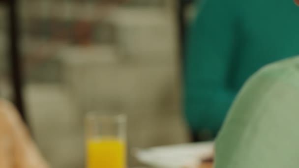 一位女士在餐桌前观看她的手机时的近景 一部黑色荧幕手机 桌上的Juice — 图库视频影像