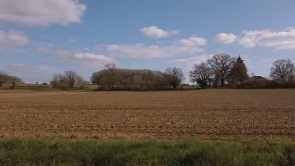 春の日差しの中で不毛の農家のフィールドに遅いカメラパン — ストック動画