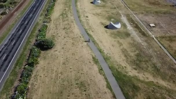 空中撮影 ナピエ ニュージーランドの自転車トラック上の人のサイクリングの追跡 より高い角度のリアショット — ストック動画