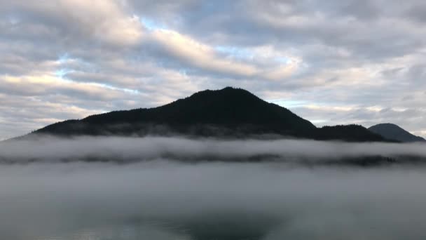 从一艘黑暗的船上看缓慢的运动 阿拉斯加高山在晨光的层层后面 是海洋的雾气 — 图库视频影像