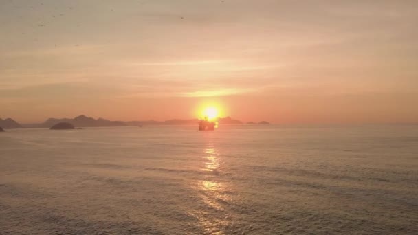 在面对太阳的科帕卡巴那 里约热内卢海岸线外的一个石油平台的空中进场缓慢 日出期间海上钻机的轮廓 — 图库视频影像