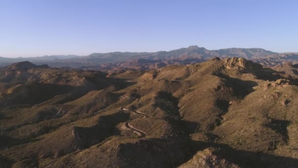 Aerial ゴールデンアワーの砂漠の山道 — ストック動画