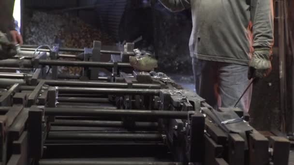 工場内の鋳造物に液体金属を注ぐ人々の側面図 — ストック動画