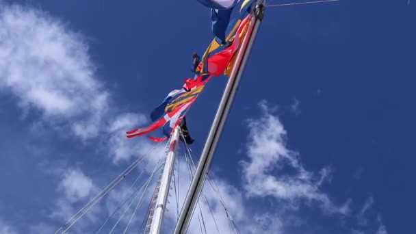 泛起五彩缤纷的彩旗 迎风迎风飘扬 船桅上飘扬着云彩和蓝天 — 图库视频影像