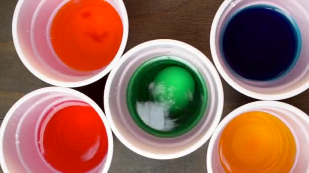 Top View Five Cups Water Different Colors Food Coloring Eggs — Stock video