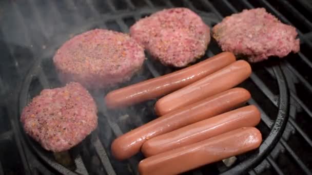 Outdoor Grill Closeup Raw Seasoned Beef Hamburger Patties Hot Dogs — Stock Video