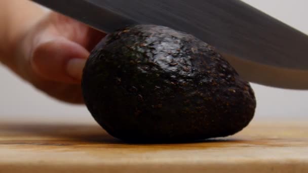 Person Schneidet Eine Avocado Auf — Stockvideo