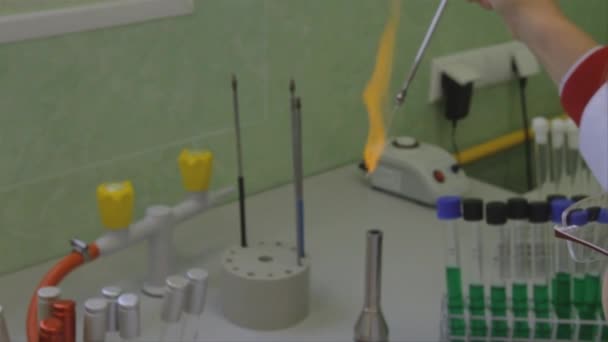 在科学实验室里 当科学家在明火上方拿着的一根细管子周围发生化学反应时 就会产生五彩缤纷的橙色火焰 — 图库视频影像