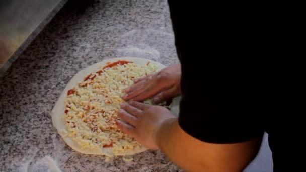 比萨烘焙准备 厨师在披萨面团上的酱汁上涂上奶酪 — 图库视频影像