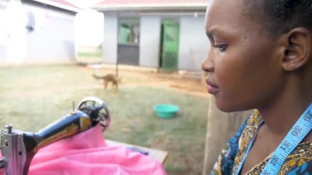 Zbliżenie Strzał Boku Afrykańskiej Kobiety Twarz Jak Szyje Ubrania Maszynie — Wideo stockowe