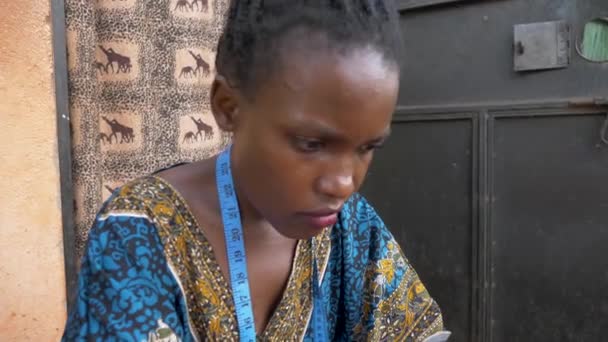 Κοντινό Πλάνο Ενός Προσώπου Αφρικανών Γυναικών Καθώς Ράβει Ρούχα Έξω — Αρχείο Βίντεο