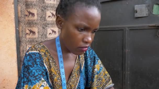 Afrika Bir Kadının Evinin Dışında Kıyafet Dikerken Çekilmiş Yavaş Çekim — Stok video