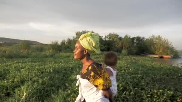 Tir Pistage Côté Une Mère Africaine Avec Son Bébé Sur — Video