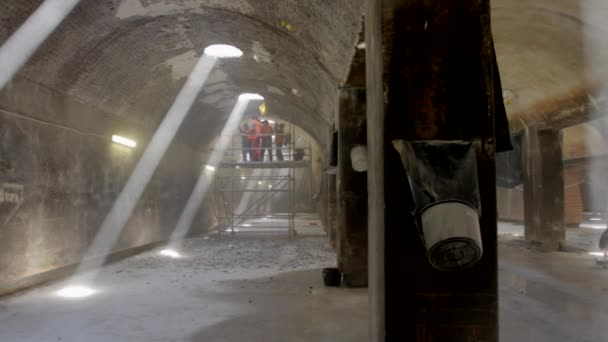 大規模な古い貯水池の労働者は 天井の壁からスクラップしている — ストック動画