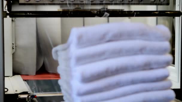 白いタオルは透明保護箔で包まれています 大規模な産業用洗濯機の中 — ストック動画