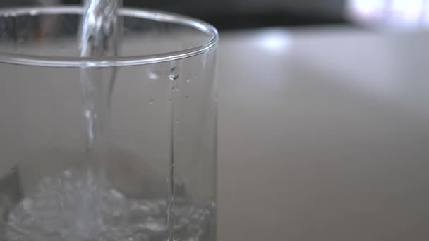 缓慢运动的宏观水柱被倒入透明的玻璃杯中 气泡浮出水面 — 图库视频影像