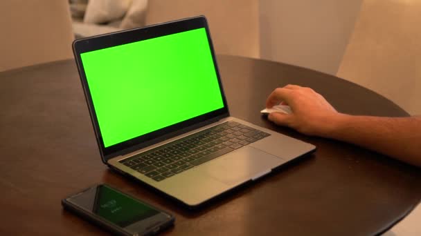 Чоловік Використовує Ноутбук Мобільний Телефон Передньому Плані Зелений Екран — стокове відео