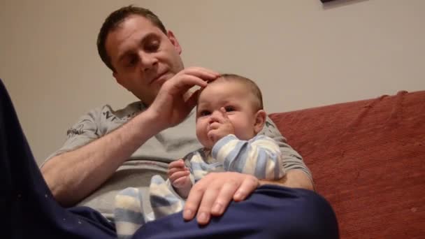 Πατέρας Αγκαλιάζει Παιδί Του Έξι Μηνών Που Βλέπει Τηλεόραση — Αρχείο Βίντεο