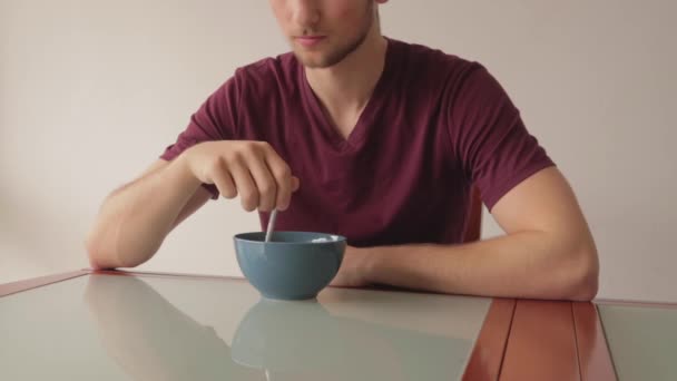 Ainda Tiro Jovem Comendo Cereais Sentado Uma Mesa Vidro Dentro — Vídeo de Stock