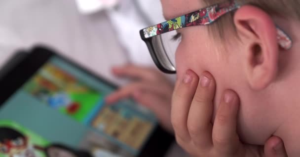 Niño Seis Años Leyendo Una Tableta Mientras Está Acostado Cama — Vídeo de stock