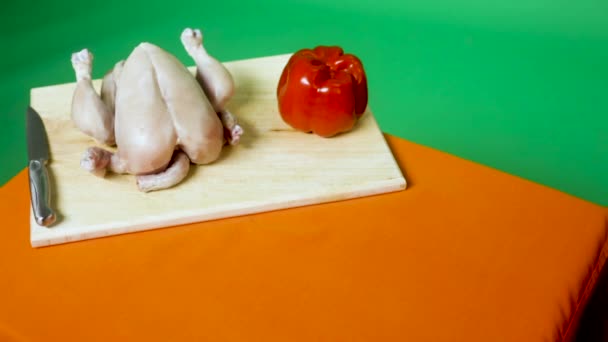 全体の鶏 トマトと緑の背景とまな板上のナイフ — ストック動画