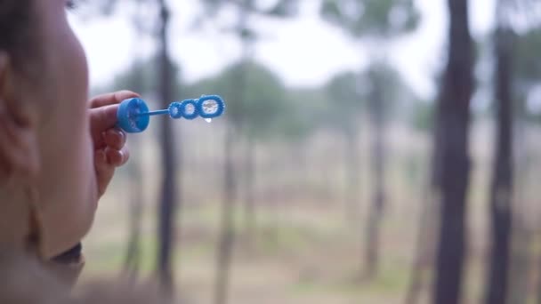 Sopra Spalla Una Ragazza Che Soffia Bolle Una Foresta — Video Stock