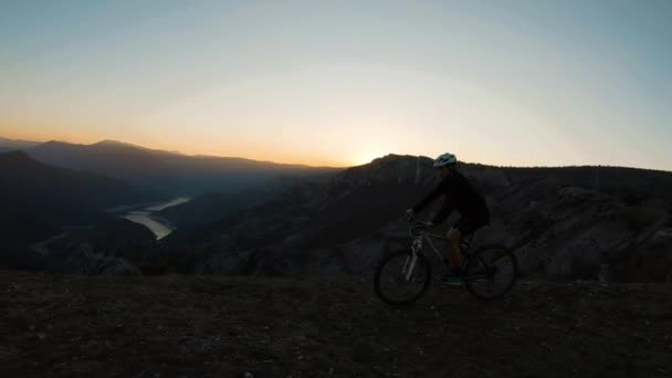 Férfi Biciklizés Hegytetőn Egy Gyönyörű Kanyon Naplementekor Háttérben Oldalról Nézve — Stock videók