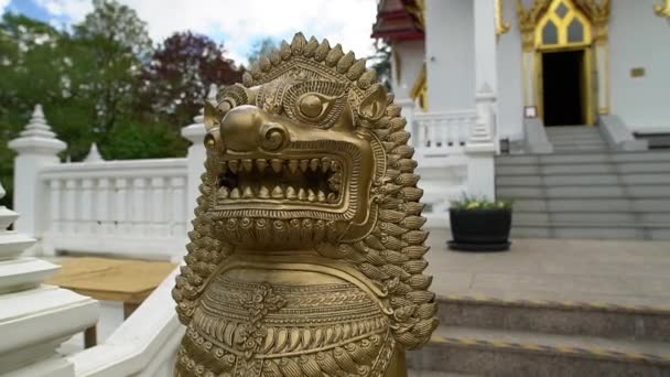 隠されたタイの仏教寺院の前に石獅子像が立っている — ストック動画