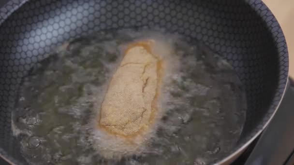 Burbujas Aceite Mientras Fríe Pechuga Pollo Una Olla Negra — Vídeos de Stock