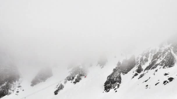 冬にフランスアルプスの低い雲の中に向かって山の側面にスキーリフトバブルの時間経過 — ストック動画