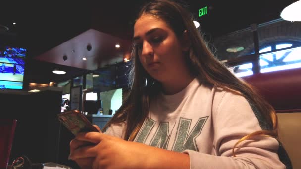 Statyczne Ujęcie Nastoletniej Kobiety Telefonie Restauracji Oglądającej Media Społecznościowe Piszącej — Wideo stockowe