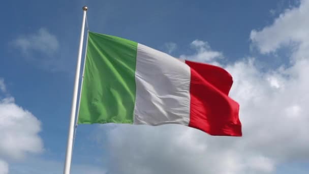 背景にはロイヤルブルーの空と雲が広がる強い風の中で ほぼ真っ直ぐなイタリアの緑 赤の旗を振って — ストック動画