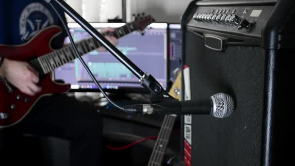 Musiker Spielt Gitarre Mit Verstärker Und Mikrofon Vordergrund Aufnahme Computer — Stockvideo