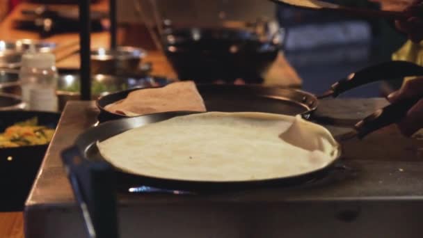 一只平底锅的慢动作镜头 上面有一个煎饼 是用一只手在街上的市场上移动的 — 图库视频影像