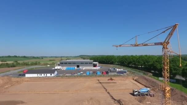 ドローンは 巨大な生産ホールが建設されている大規模な建設現場の上空を飛ぶ — ストック動画