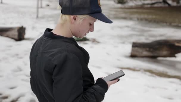 Une Personne Tient Dans Neige Vérifiant Son Téléphone — Video