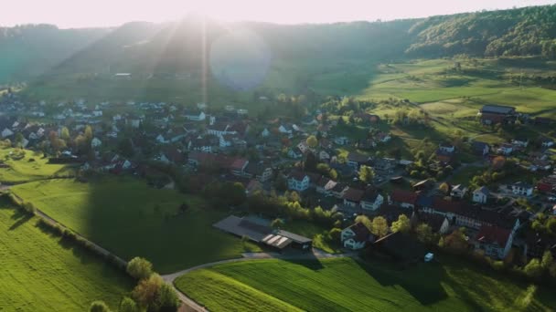 緑の森の小さなスイスの村の集落の空中ビューは カントンアルガウスイス 春の黄色の花 村の教会で谷をカバー — ストック動画