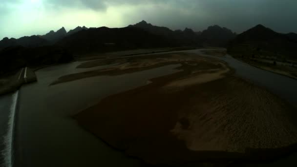 ダムの後ろに美しい雄大な山々の空中ビュー ダムの緑の水 ダムは部分的に乾燥した表面を持っています — ストック動画