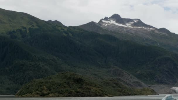 一座巨大的冰川坐落在岩石和绿色的阿拉斯加山脉之间 位于朱诺的阿拉斯加峡湾内 — 图库视频影像