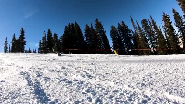 一个雪人在雪地上停了下来 在相机上喷了些雪 完全覆盖了屏幕几秒钟 犹他山脉 阳光明媚 背景中的松树 — 图库视频影像