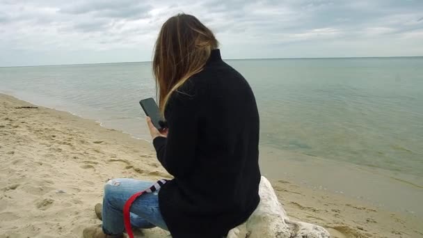Young Girl Sits Upside Branch Seashore Her Mobile Phone — Stock Video