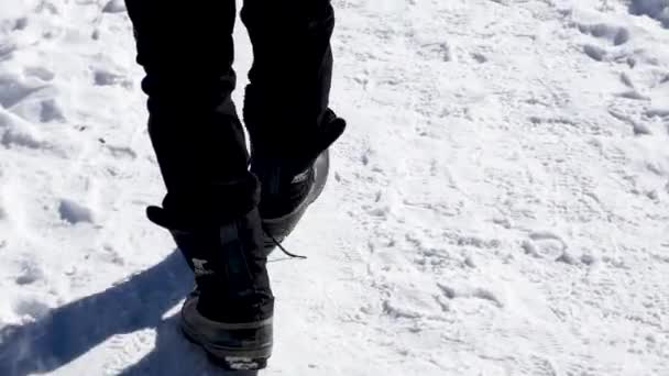 Hombre Caminando Las Montañas Nevadas Cámara Lenta Panorámica Pies Cabeza — Vídeos de Stock