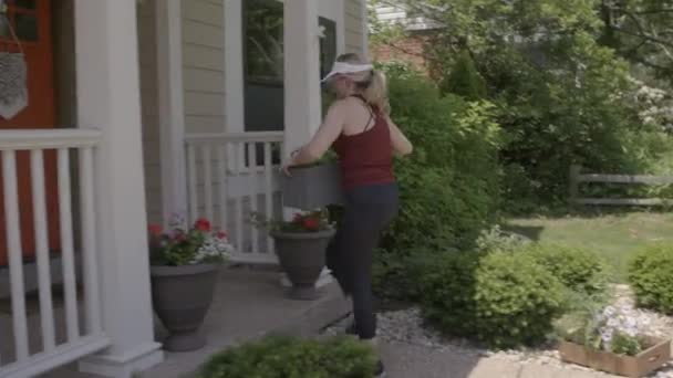 Una Mujer Jardinería Patio Delantero Establece Una Maceta Con Plantas — Vídeo de stock