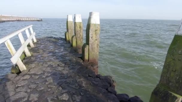 从一个有木制栏杆和支柱的石墩上俯瞰大海 潘宁铅球 — 图库视频影像